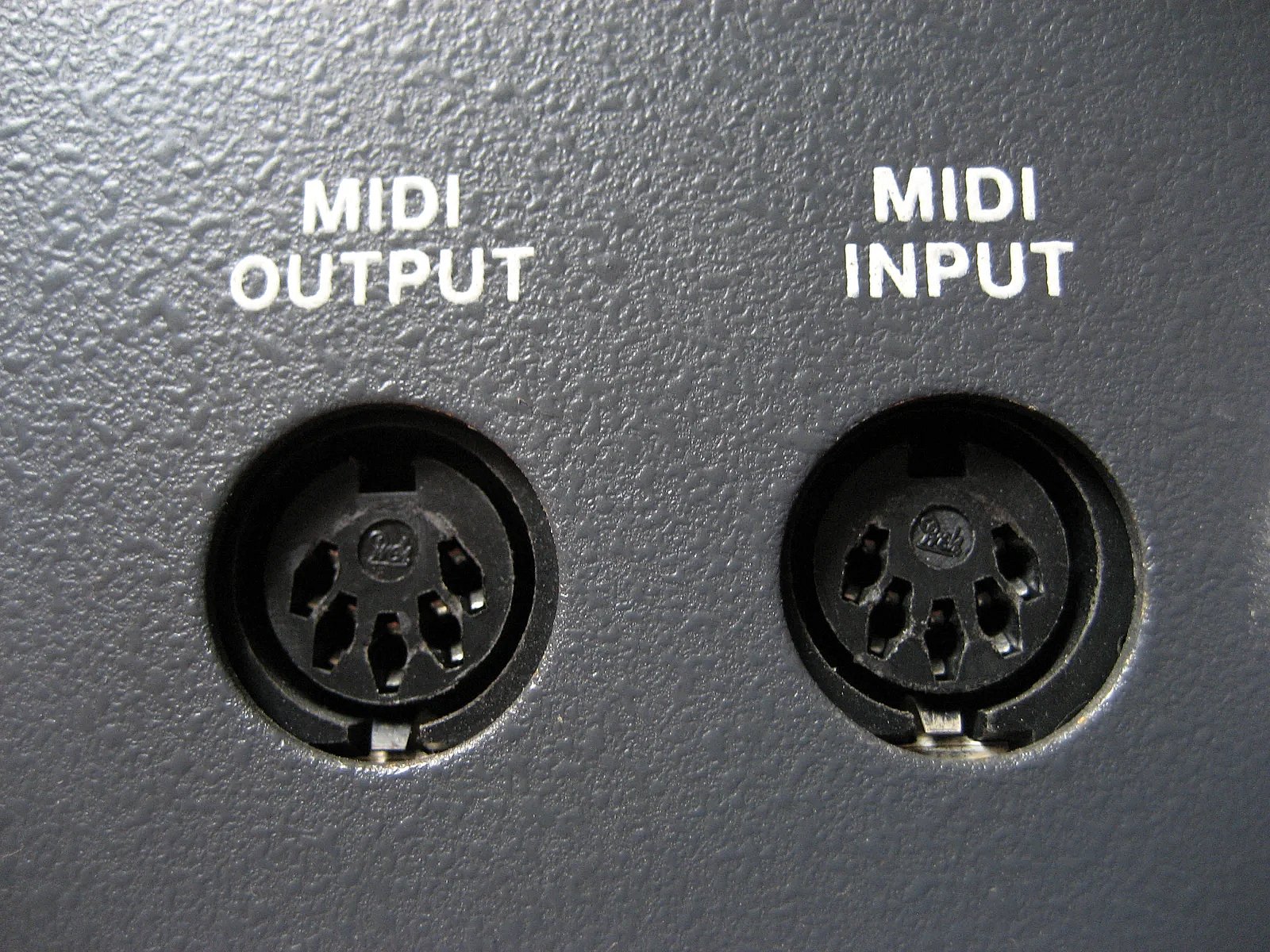 Dwa pięciopinowe gniazda DIN opisane MIDI OUTPUT i MIDI INPUT